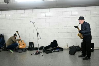 In an airy spot between two escalators a small group of musicians are unpacking their instruments, checking their music and calming any last minute nerves