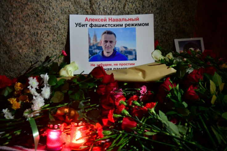 Flowers are laid next to a picture of late Russian opposition leader Alexei Navalny at a makeshift memorial organized at the monument to the victims of political repressions in Saint Petersburg on February 16