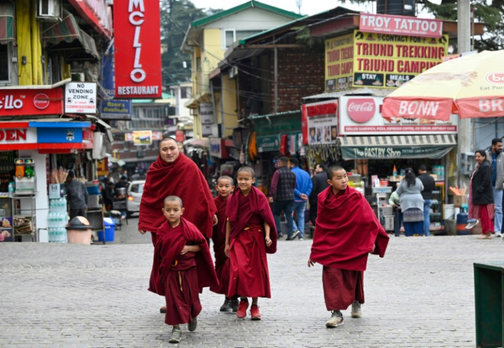 Buddhist monks walk down a street in McLeod Ganj near Dharamsala on February 18, 2024