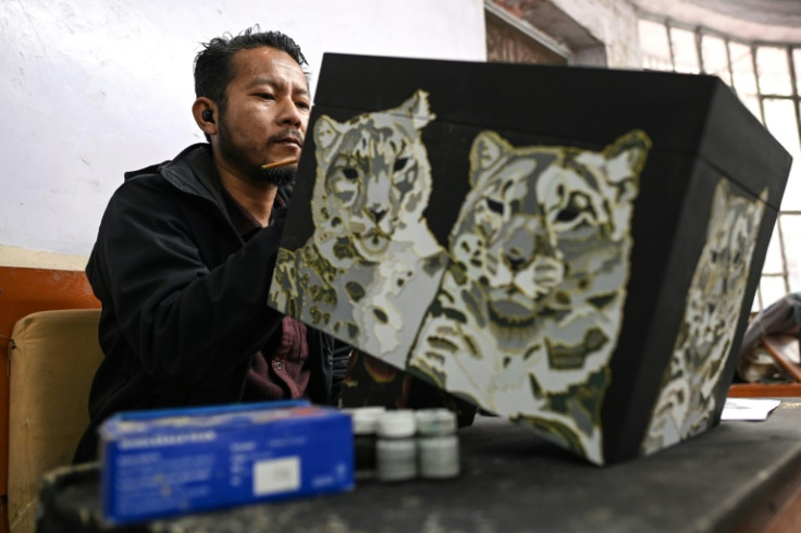 A Tibetan artisan gives the final touches to a 'Thangka', a traditional Tibetan Buddhist painting at the Norbulingka Institute in Dharamsala
