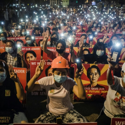 Protesters hold up the three-finger salute and placards with the image of detained Myanmar civilian leader Aung San Suu Kyi during a March 2021 protest against the military coup