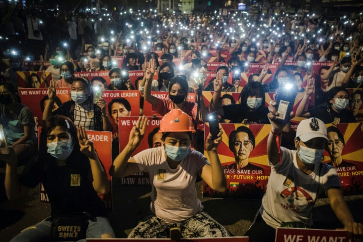 Protesters hold up the three-finger salute and placards with the image of detained Myanmar civilian leader Aung San Suu Kyi during a March 2021 protest against the military coup