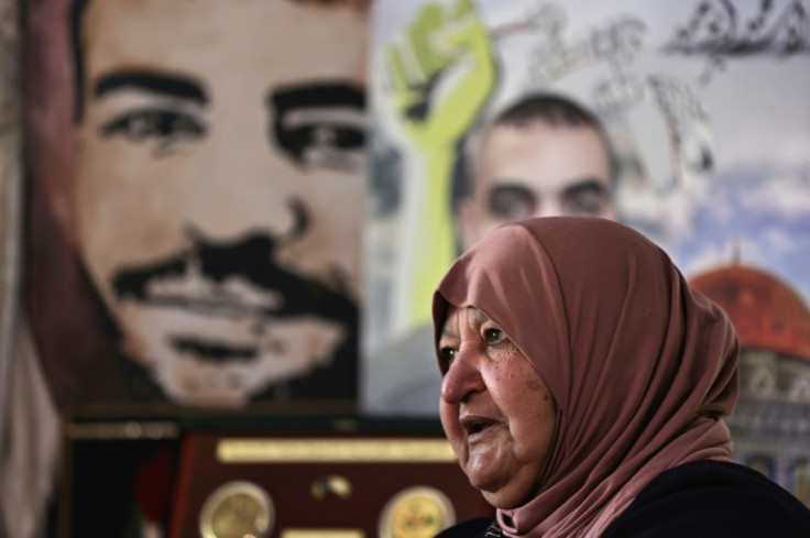 Latifa Abu Hamid, 74, sits near portraits of her children, at her house in Ramallah in the occupied West Bank