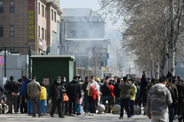 People gather as they watch rescue operations at the scene of a suspected gas explosion in China's northern Hebei province