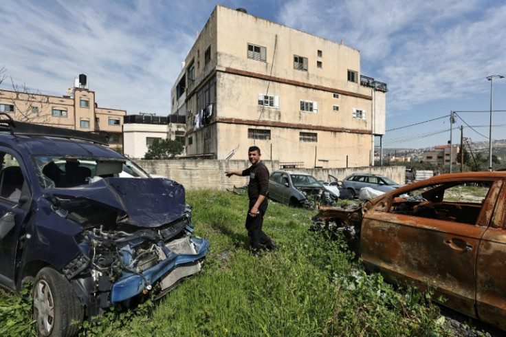 Palestinian mechanic Motaz Qassrawi shows cars he says were damaged when settlers attacked Huwara
