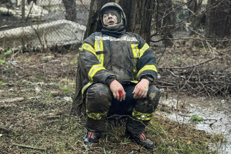 An injured rescuer leans next to a tree following a missile attack in Odesa