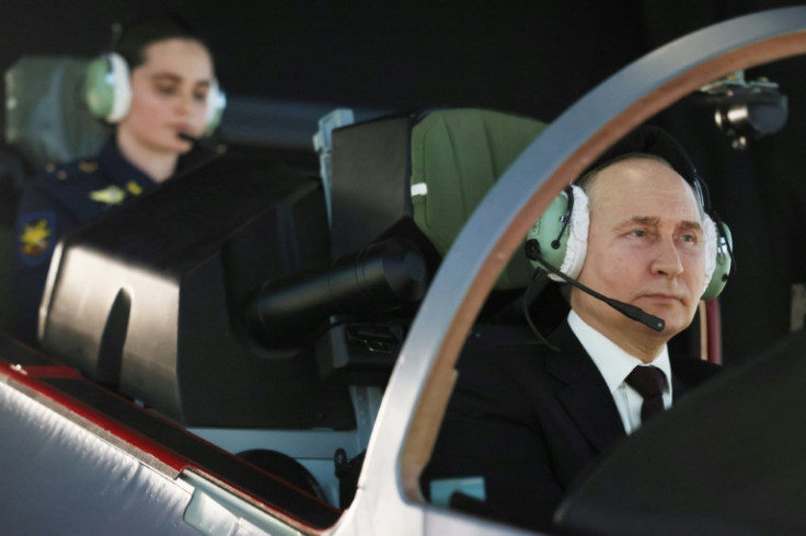 Russian President Vladimir Putin operates a simulator during a visit to the Krasnodar Higher Military Aviation School of Pilots