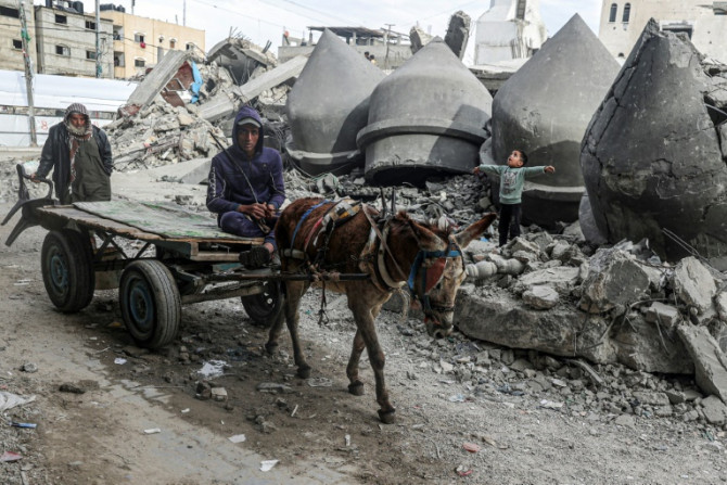A donkey-pulled cart passes the rubble of Al-Faruq Mosque, destroyed during Israeli bombardment in Rafah, the southern Gaza Strip, where Israel says it will send in ground troops