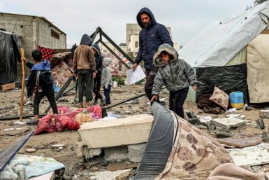 Displaced Palestinian civilians recover what they can from the battered remains of their camp after an overnight Israeli bombardment of Rafah in the southern Gaza Strip