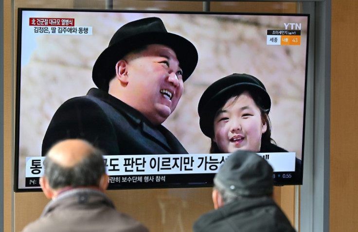 People watch a television screen showing a news broadcast with an image of Kim Jong Un and daughter Ju Ae