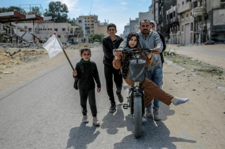 A girl holds a white flag as a displaced Palestinian family walks in Gaza City, in the territory's north where aid workers say the humanitarian situation is particularly acute