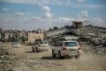 UN vehicles drive past buildings destroyed by previous Israeli strikes Gaza City