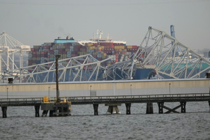 The steel frame of the Francis Scott Key Bridge sits on top of a container ship after it struck the bridge in Baltimore, Maryland, on March 26, 2024