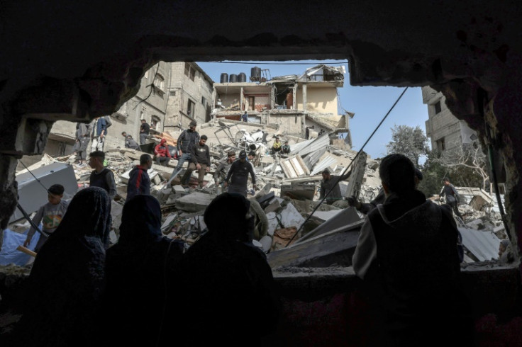 Palestinians check the rubble of buildings that were destroyed following overnight Israeli bombardment in Rafah, in the southern Gaza Strip