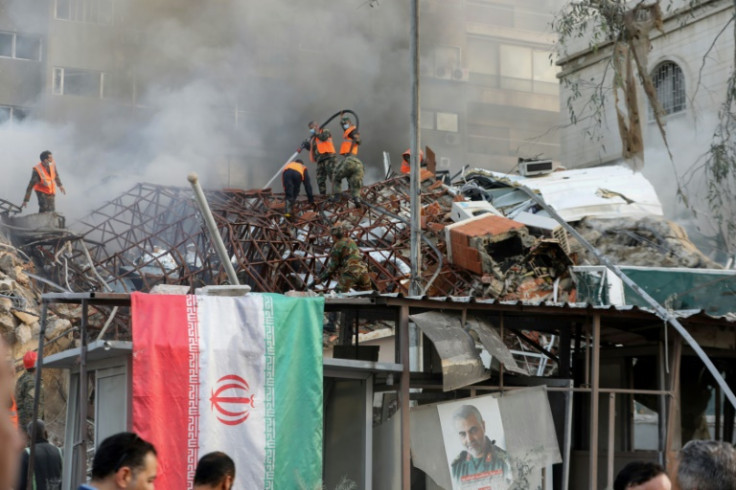 An Iranian flag is draped over the railings outside the flattened consular annex of the Iranian embassy in Damascus