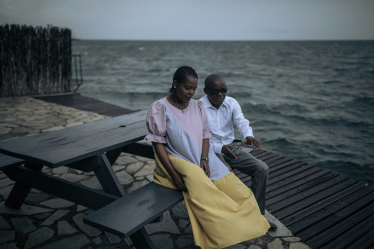 Rachel Sematumba and her father Onesphore Sematumba sit by Lake Kivu, which marks the border between the Democratic Republic of Congo and Rwanda