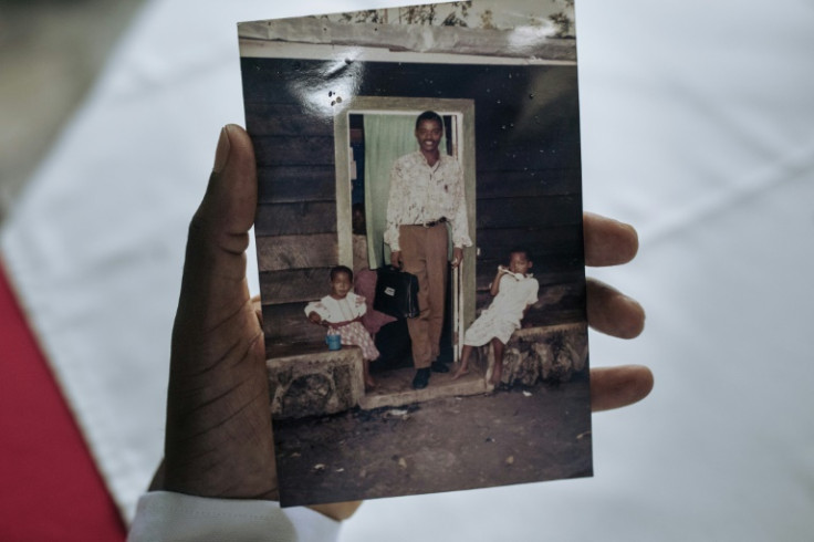 Onesphore Sematumba holds a photograph of two of his daughters, taken between 1996-1997, in Goma