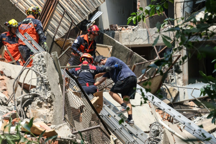 A Central News Agency photo shows emergency workers assisting a survivor after he was rescued from a damaged building in New Taipei City