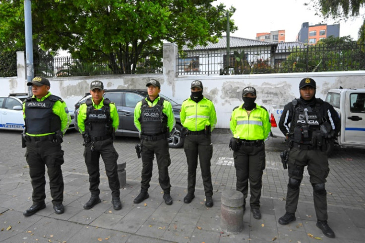 Police officers stand outside the Mexican embassy in Quito