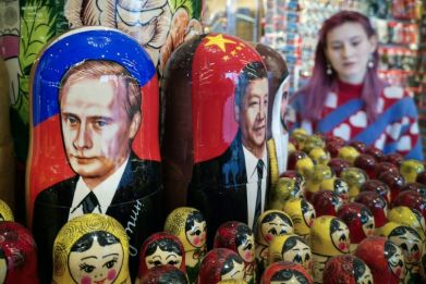 Traditional Russian nesting dolls depict Vladimir Putin (L) and his Chinese counterpart Xi Jinping at a gift shop in Moscow