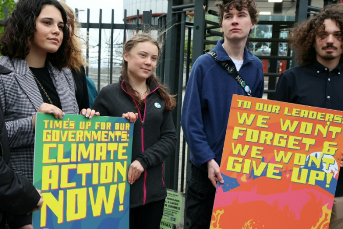 Swedish climate activist Greta Thunberg (C) was among those standing outside the court