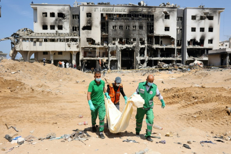 Palestinian civil defence staff recover human remains at the grounds of Gaza's Al-Shifa hospital which was largely destroyed during army raid that Israel said targeted hundreds of militants holed up inside