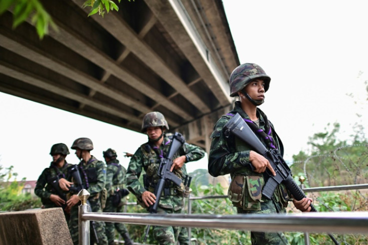 Thai military personnel stand guard overlooking the Moei river on the Thai side of the shared border with Myanmar