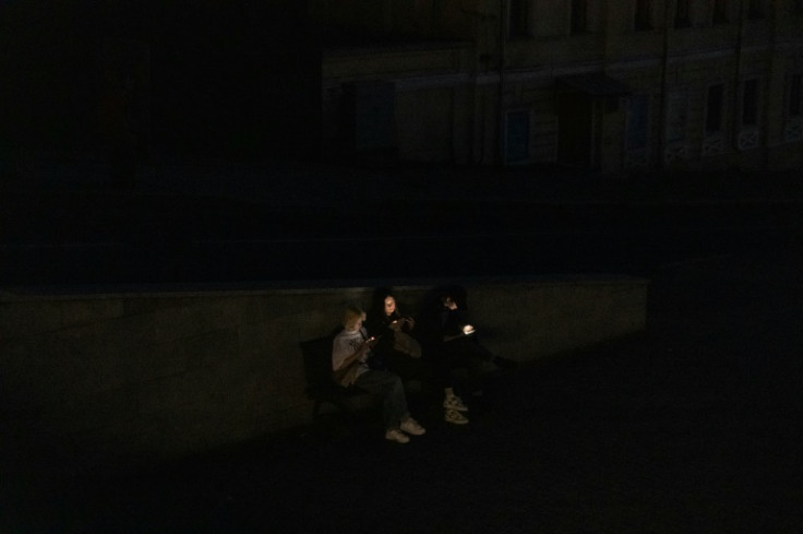 People check smartphones during a blackout following Russian attacks on the Kharkiv energy infrastructure