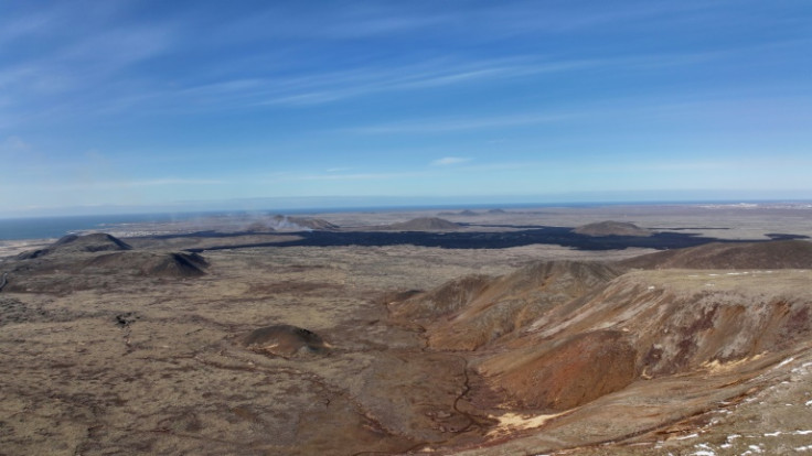 The dark lava field and crater from the current eruption at Sundhnukagigar near Grindavik in southwest Iceland is visible in the background