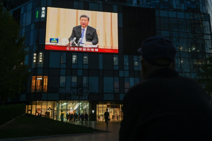 A large screen shows news coverage of Chinese President Xi Jinping meeting with German Chancellor Olaf Scholz