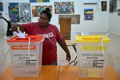 A woman drops her ballot paper into a box as the Solomon Islands general election begins
