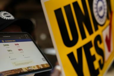 A man holds up an iPad showing that the unionization effort succeeded after the United Auto Workers (UAW) received enough votes to form a union at a UAW vote watch party on April 19, 2024 in Chattanooga, Tennessee