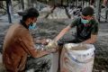 Workers ration out flour during the distribution of humanitarian aid in Gaza City