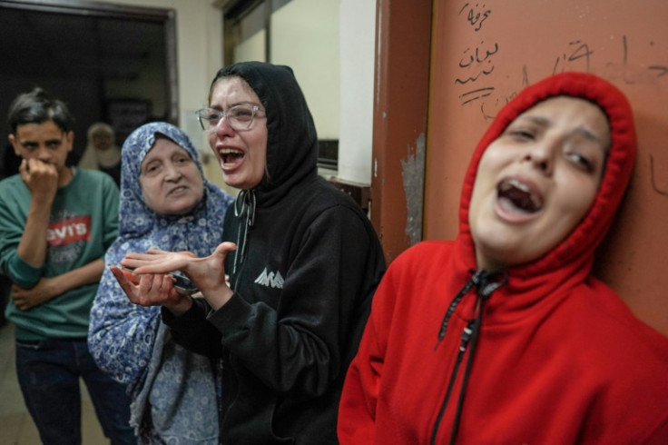 Palestinians react as relatives receive treatment at a hospital in Deir al-Balah, Gaza