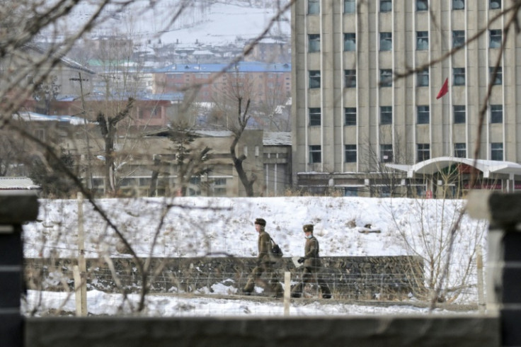 Two North Korean soldiers walk in the village of Hyesan, as seen from Changbai in China's northeast Jilin province
