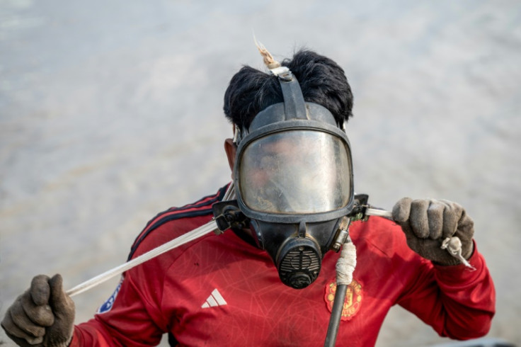 A diver in Myanmar works to recover a sunken ship in the Yangon River, plunging down to attach cables to the wreck and using the power of the tides to bring the boat to shore