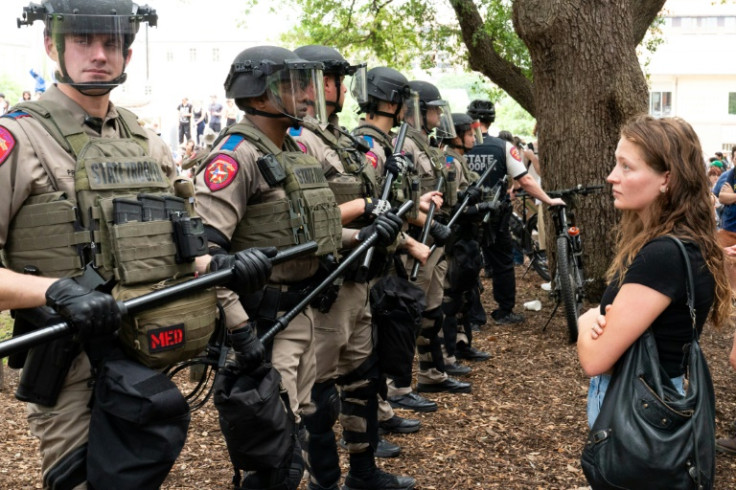 A student quietly stares at a row of Texas State Troopers as pro-Palestinian students protest the Israel-Hamas war on the campus of the University of Texas in Austin, Texas, on April 24, 2024