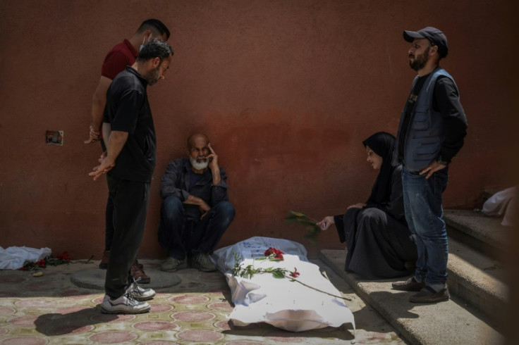 People mourn over the body of a missing relative unearthed at Nasser hospital in Khan Yunis