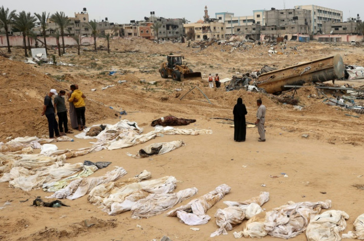 People gather near bodies lined up for identification after Gaza's Civil Defence agency said almost 400 corpses were recovered from mass graves at Nasser Medical Complex