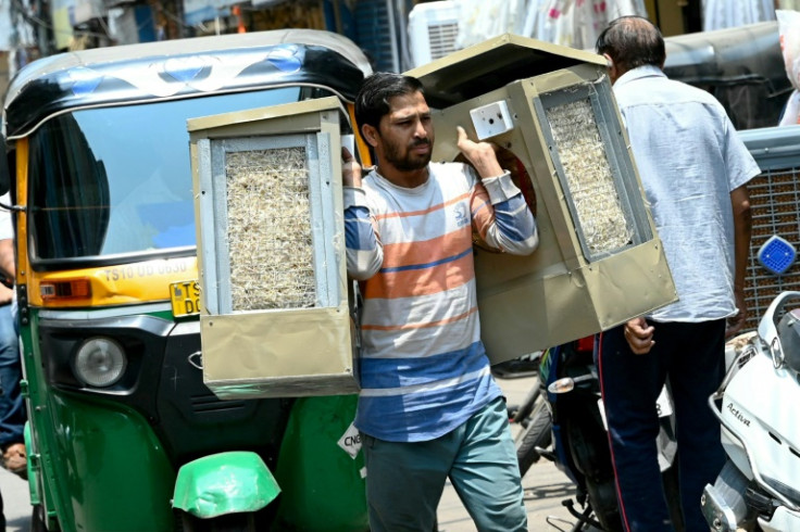 A worker carries air coolers in Hyderabad, with Indian forecasters saying a severe heatwave would continue through the weekend