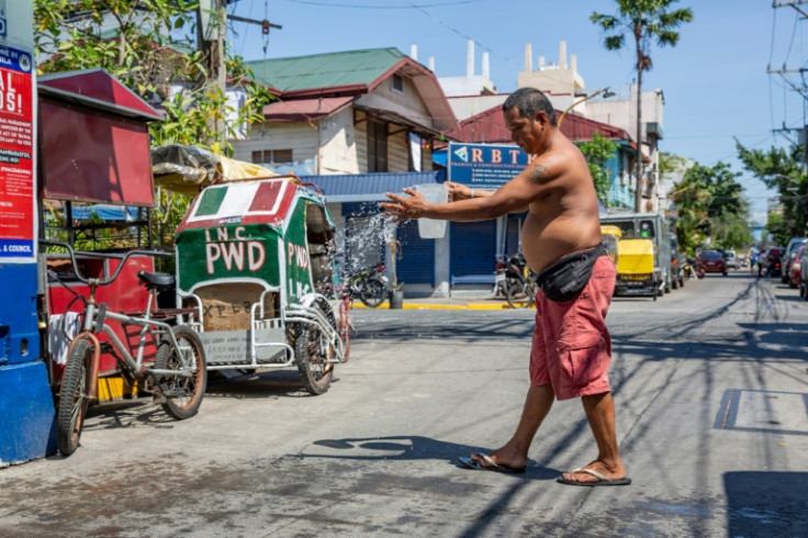 A man douses himself with water during a heatwave in Manila