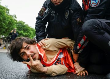 Turkish police detain a protester as he and others attempt to march to Taksim Square,
