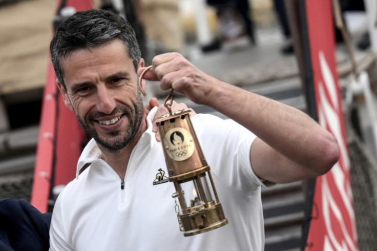 Chief Paris Games organiser Tony Estanguet poses with the Olympic flame in Greece in April