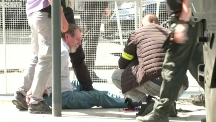 Security personnel apprehend the suspected gunman