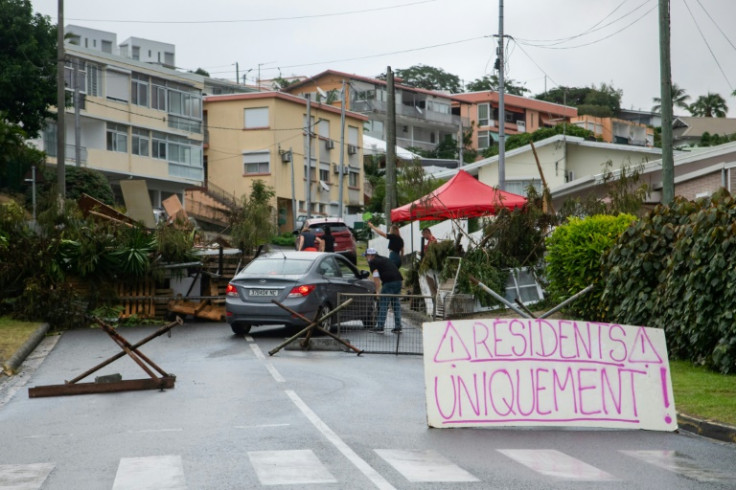 A sign at a roadblock in Portes de Fer district reads 'Residents only!' as a car is checked