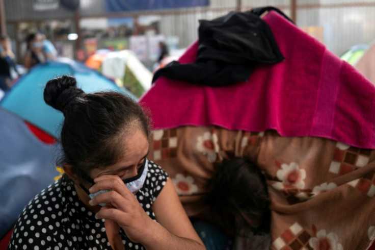 A migrants cries next to her tent at a shelter in Tijuana as she talks about her ordeal