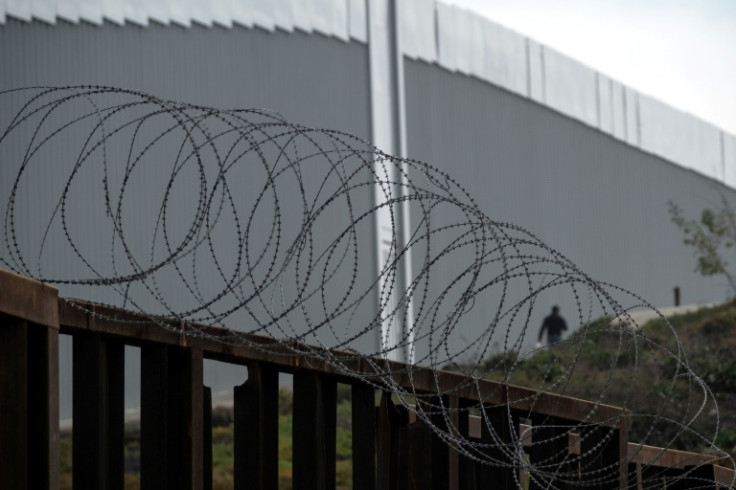 A man crosses the Mexican-US border though a gap in the fence -- part of a migration wave that will pose a major challenge to Mexico's next president