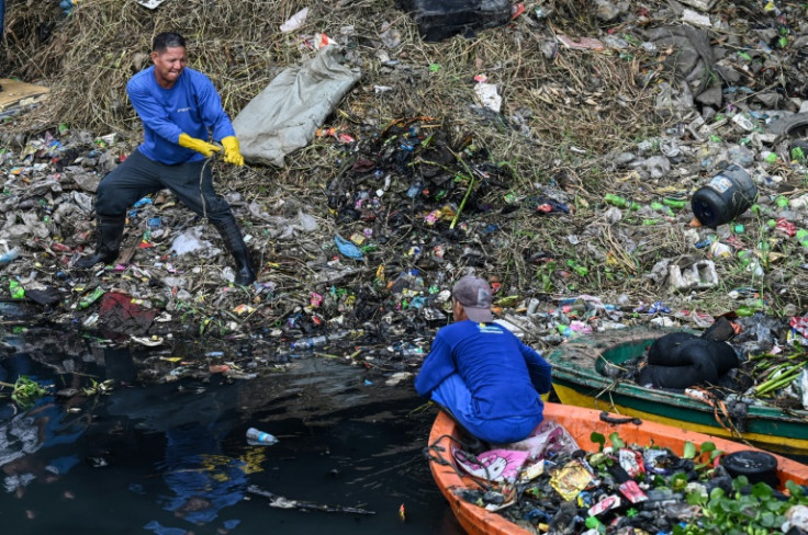 Government workers pick up trash under a bridge in Paranaque, Metro Manila