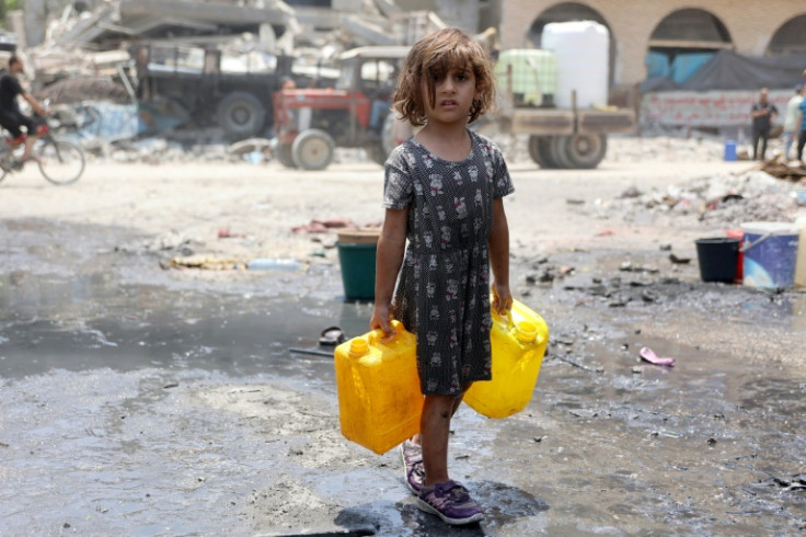 A Palestinian girl carries water containers in Jabalia refugee camp in the northern Gaza Strip on June 3, 2024