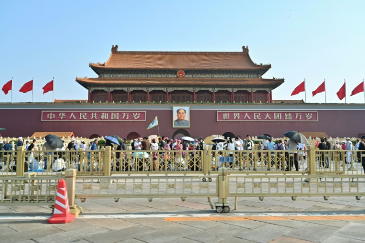 People walk past the portrait of late Communist leader Mao Zedong at the entrance to the Forbidden City at Tiananmen Square in Beijing on June 4, 2024
